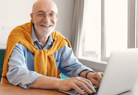 Man sitting working on his laptop smiling