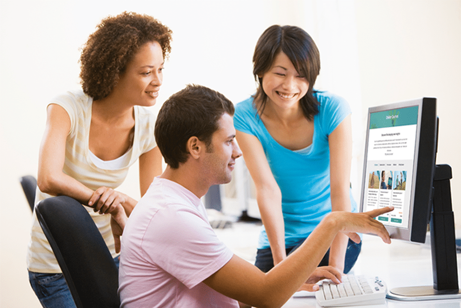 Three adults smiling looking at a computer