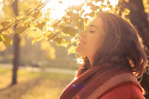 Understanding anxiety - lady smiling with her eyes shut in an autumn setting